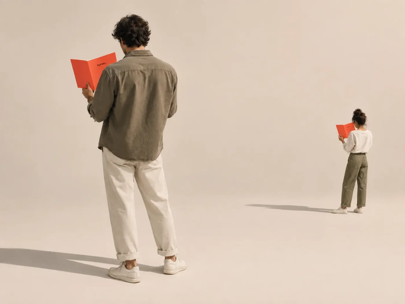 Two people reading coral thePath booklets, one close by and one standing far off across an open room.
