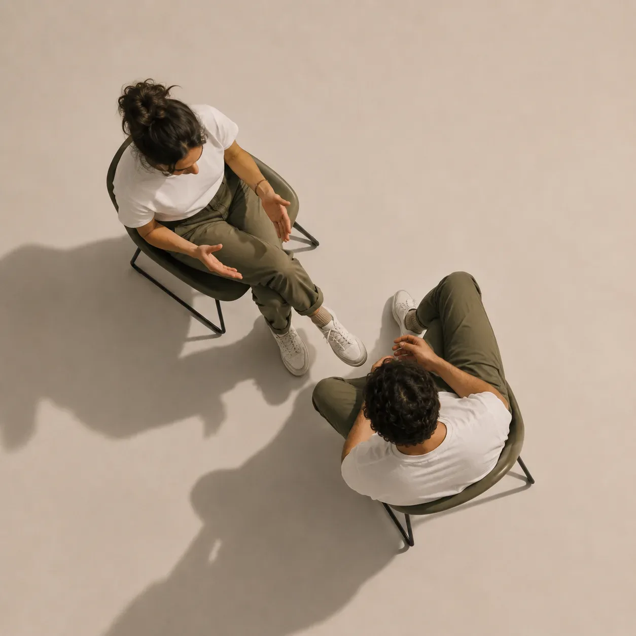 Two people seated in conversation, seen from above.