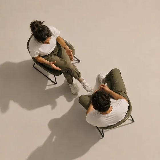 Two people seated in conversation, seen from above.
